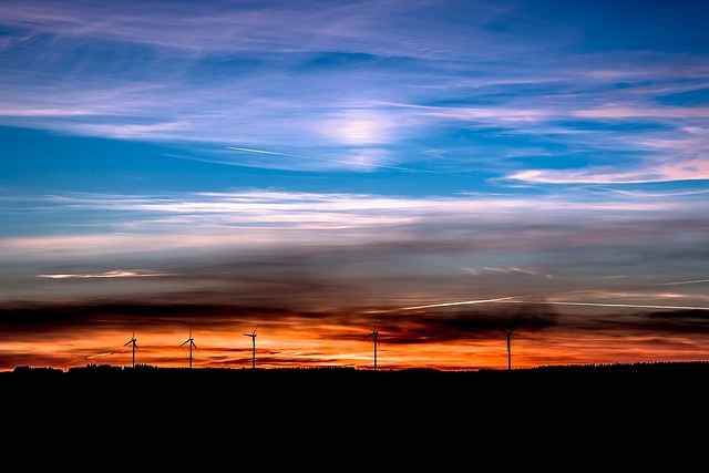 Wind turbines silhouetted against a vibrant sunset, symbolizing China's shift towards renewable energy and the growth of Green Electricity Certificates (GECs).